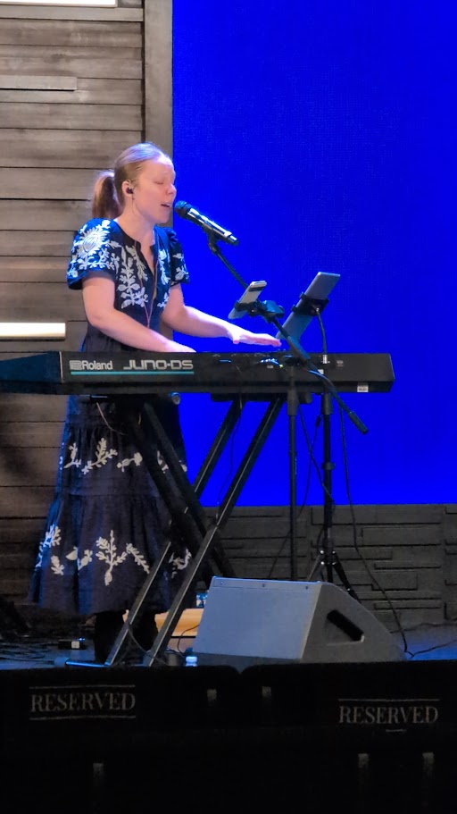A woman singing and playing keyboard during worship at New Life Hutto